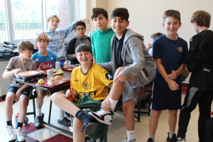  boys in the cafeteria showing off their shoes